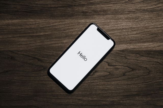 A smartphone displaying 'Hello' on a wooden surface, showcasing modern technology.